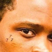 a close up of a man with a tattoo on his face